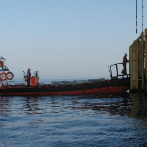 Rib 1 on a flat calm morning docks to transfer workers