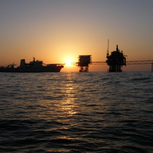 Ship, rigs, air bridge at sunset