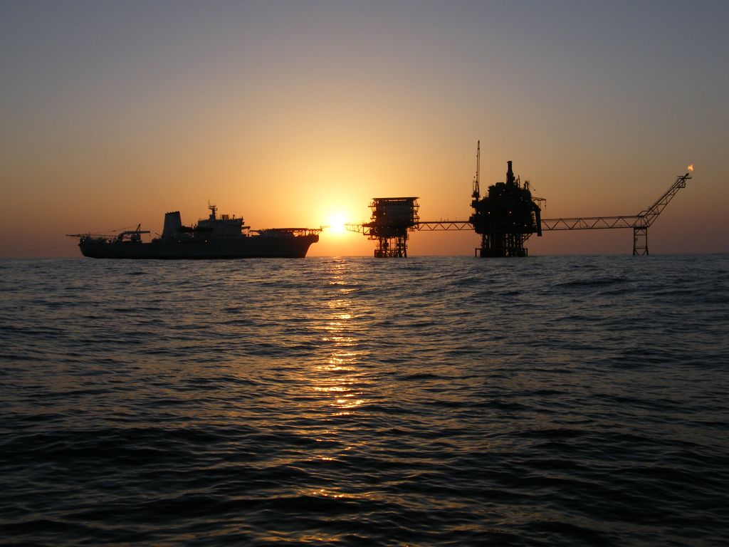 Ship, rigs, air bridge at sunset